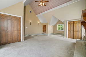 Additional living space featuring high vaulted ceiling, light carpet, ceiling fan, and baseboard heating