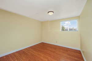 Unfurnished room featuring wood finished floors and baseboards