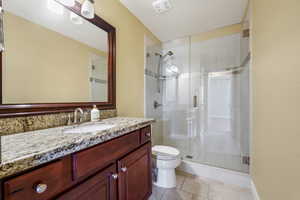 Bathroom featuring a shower stall, vanity, and light tile patterned floors