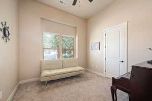 Living area with carpet floors and ceiling fan