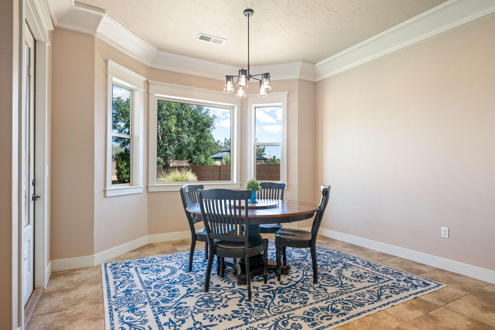 Dining room with ornamental molding, a chandelier, and a textured ceiling