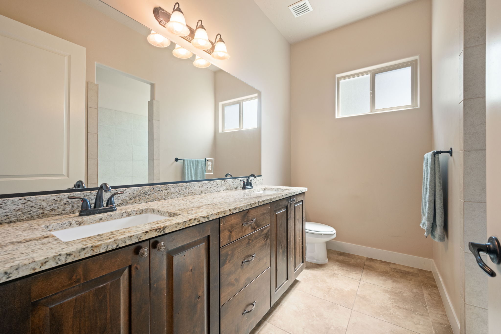 Bathroom featuring double vanity and light tile patterned floors