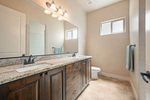 Bathroom featuring double vanity and light tile patterned floors