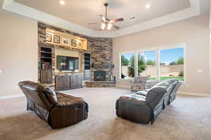 Living room with a raised ceiling, light colored carpet, and recessed lighting