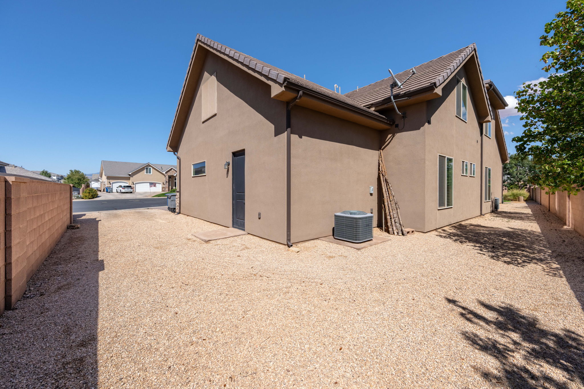 Back of house featuring stucco siding and a tile roof