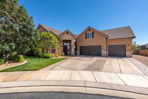 View of front facade with stone siding, stucco siding, a tiled roof, and concrete driveway