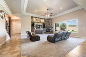 Living room with a tray ceiling, stairway, recessed lighting, light colored carpet, and light tile patterned flooring