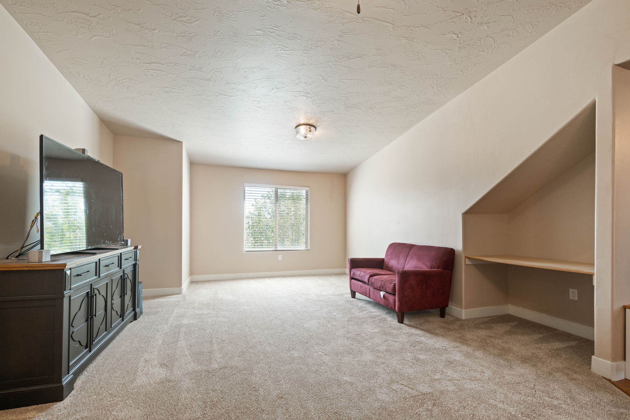 Living area with light carpet and a textured ceiling
