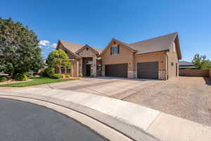 View of front of house with stone siding, concrete driveway, stucco siding, a tile roof, and an attached garage
