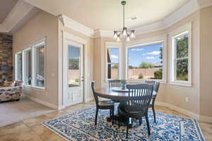 Dining area with a chandelier, crown molding, and light tile patterned floors