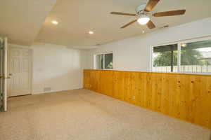 Unfurnished room with recessed lighting, carpet floors, wooden walls, and a ceiling fan