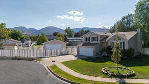 View of front of home featuring a residential view, a mountain view, a chimney, and a detached garage