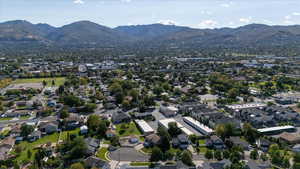 Aerial view of property and surrounding area with a mountain backdrop and nearby suburban area