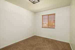 Carpeted empty room with baseboards