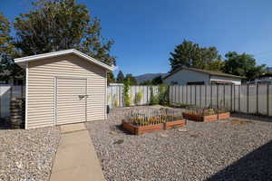 View of yard featuring a storage unit, a garden, and a mountain view