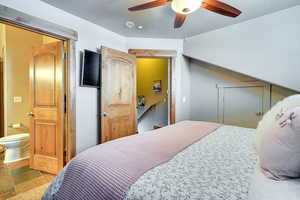 Bedroom with a textured ceiling, a ceiling fan, and ensuite bathroom