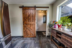 Entrance foyer featuring a barn door, dark wood finished floors, and electric panel