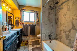 Bathroom featuring double vanity and washtub / shower combination