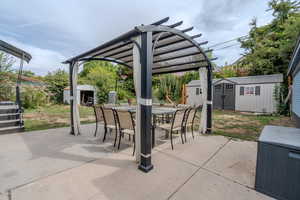 View of patio / terrace with a storage unit, outdoor dining area, and a pergola