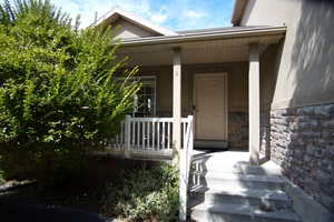 View of exterior entry featuring covered porch