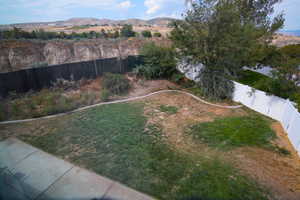 Fenced backyard featuring a mountain view