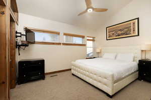Bedroom featuring vaulted ceiling, carpet floors, and a ceiling fan