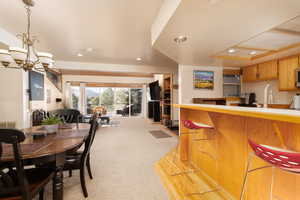 Dining area with light carpet, recessed lighting, and a chandelier