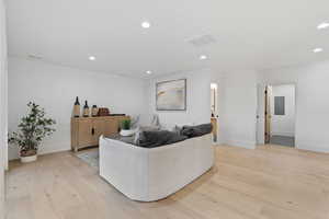 Living room featuring light wood-style floors, recessed lighting, and electric panel