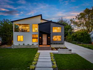 Contemporary home with a front yard, concrete driveway, and stucco siding