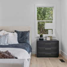 Bedroom with light wood-style flooring and baseboards