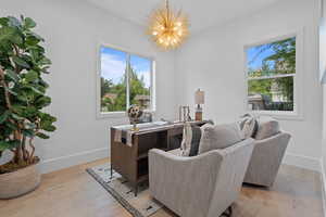 Office area featuring light wood-style floors and a chandelier