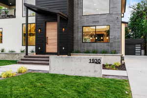 Doorway to property with a lawn and a garage
