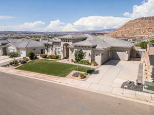 View of front facade featuring a garage, stucco siding, driveway, a tile roof, and a gate