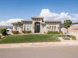Mediterranean / spanish-style house with stucco siding, a front yard, a tiled roof, and driveway