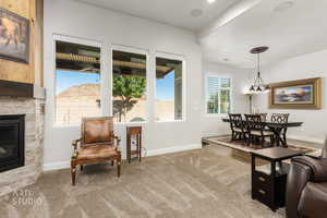 Living area featuring carpet flooring and a stone fireplace