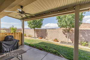 Fenced backyard with a patio and a ceiling fan