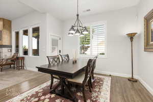 Dining space featuring wood finished floors and a chandelier