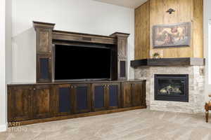 Unfurnished living room with a fireplace, carpet flooring, and wood walls
