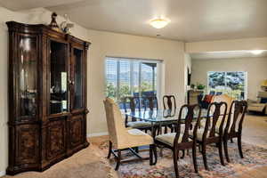 Formal dining space with light carpet and plenty of natural light