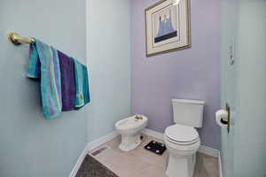 Bathroom with a bidet and tile patterned floors