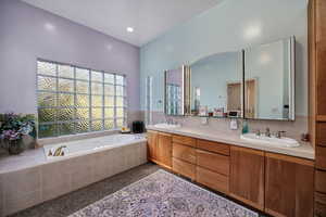Bathroom with a garden tub, double vanity, and recessed lighting