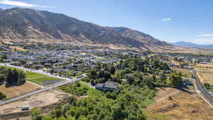Aerial view of property and surrounding area with a mountainous background and nearby suburban area