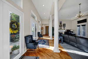 Foyer with decorative columns, wood finished floors, ornamental molding, french doors, and recessed lighting