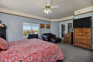 Carpeted bedroom featuring ceiling fan and access to outside