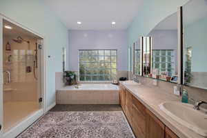 Full bathroom with a garden tub, a shower stall, double vanity, and recessed lighting
