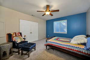 Carpeted bedroom featuring a ceiling fan and baseboards