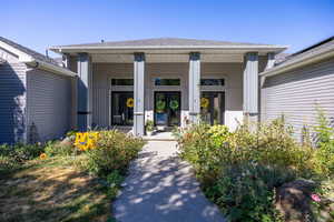Property entrance with a porch and roof with shingles