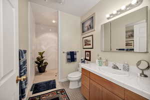 Bathroom featuring vanity, walk in shower, and light tile patterned floors