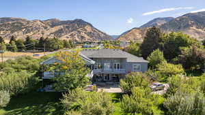 Rear view of house featuring a balcony, a patio area, and a mountain view