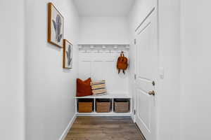 Mudroom featuring dark wood-type flooring and baseboards